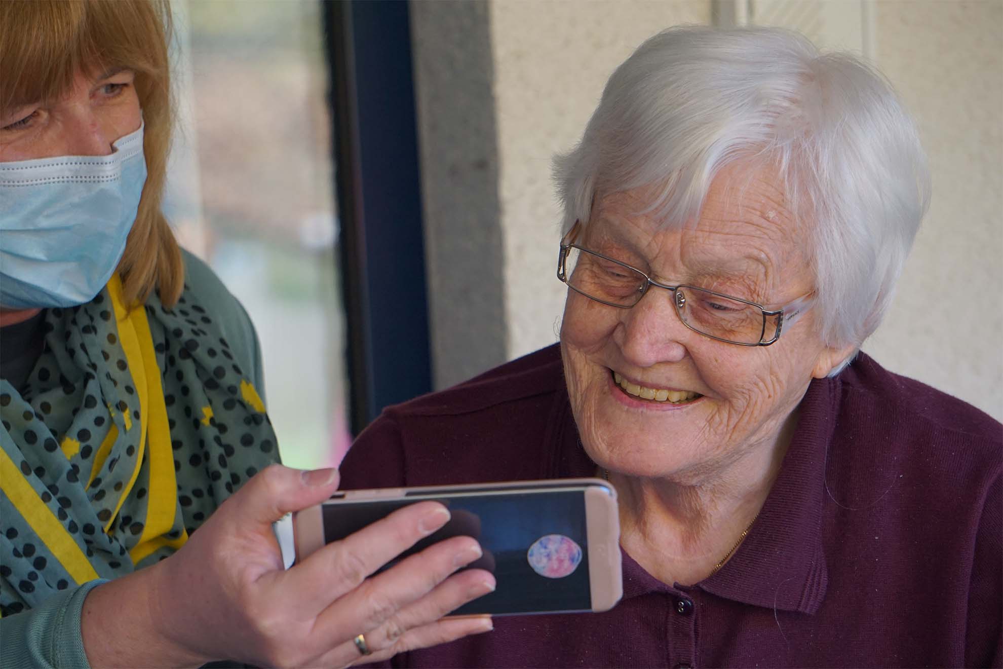 resident smiling after looking at a mobile phone