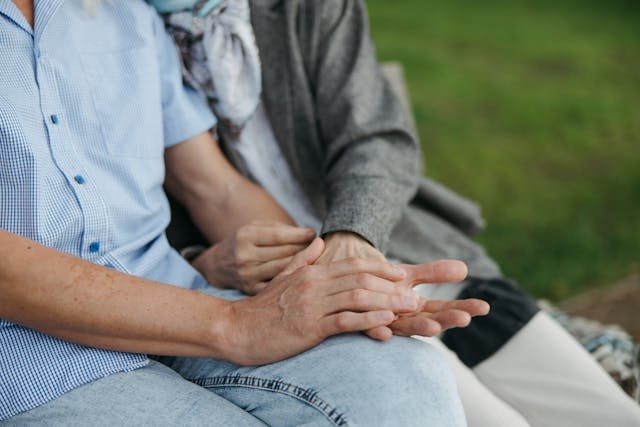 resident and carer holding hands