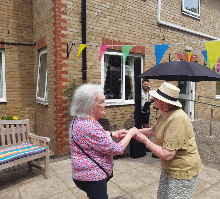 two older ladies holding hands dancing together